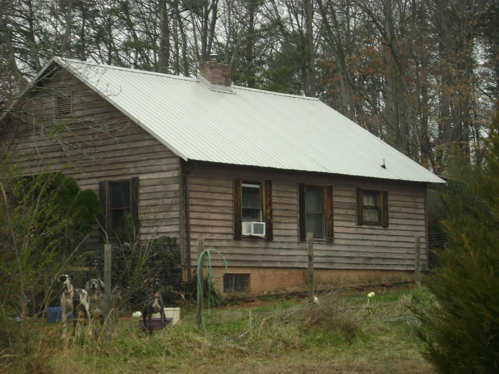 White metal roof on an old wood sided farmhouse, from a Metal Roof Installation job in Oswego